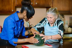 Caregiver Helping Senior Woman in Kitchen