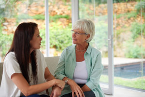 family caregiver talking with senior - navigating aging