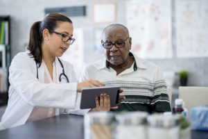 doctor showing senior man medication schedule