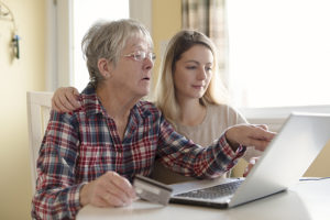 Senior woman with daughter online purchasing together