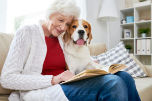 happy senior woman reading with dog