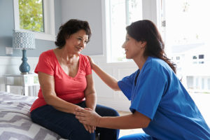 caregiver consoling senior woman