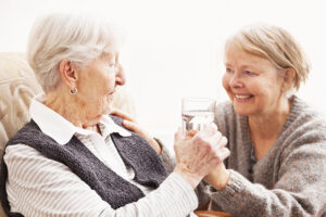 caregiver handing water to senior