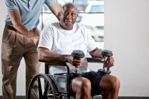 senior man in wheelchair holding weights