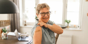 Happy senior woman with a bandaide on her arm