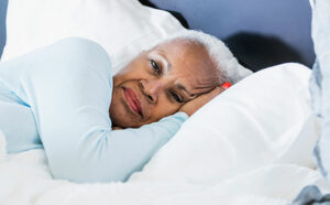 Alzheimer's-senior-woman-laying-in-bed