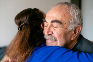 caregiver hugging senior man