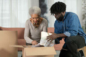 Family caregiver helping senior woman unpack boxes