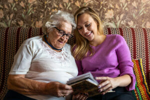 Caregiver reading with senior woman