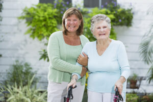 Family caregiver helping senior with a walker