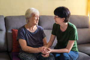  A caregiver discusses the unforeseen factors that impact Alzheimer’s symptoms with a senior. 