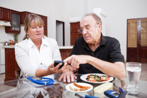 A man receiving home care for diabetes management looks at his glucose monitor.