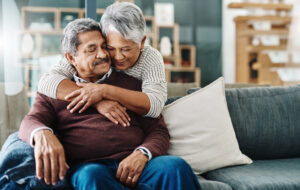 A woman who has been preparing for hospital discharge hugs her husband.