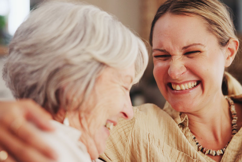 A woman and her mom share a laugh as they work on improving senior mental health through increased companionship.